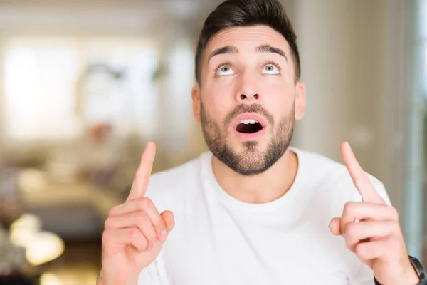 Joven Hombre Guapo Vistiendo Casual Camiseta Blanca Casa Sorprendido Sorprendido —  Fotos de Stock