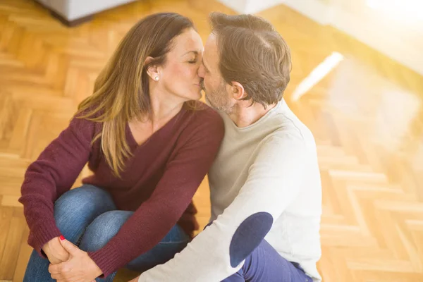 美丽的浪漫情侣坐在一起在地板上亲吻在家里的爱 — 图库照片