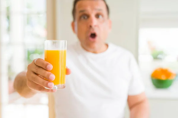 中年男子在家喝了一杯橙汁 吓得面目全非 害怕和兴奋的恐惧表情 — 图库照片