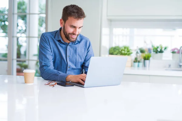 Hombre de negocios guapo trabajando con computadora portátil y sonriendo —  Fotos de Stock
