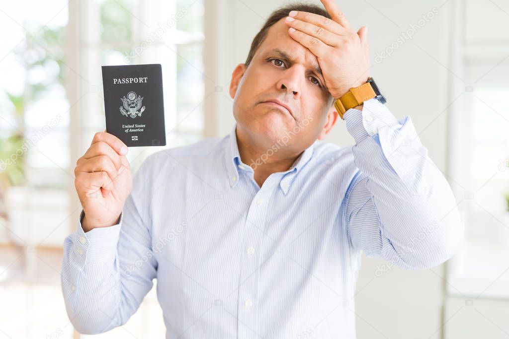 Middle age man holding holding passport of United States stressed with hand on head, shocked with shame and surprise face, angry and frustrated. Fear and upset for mistake.