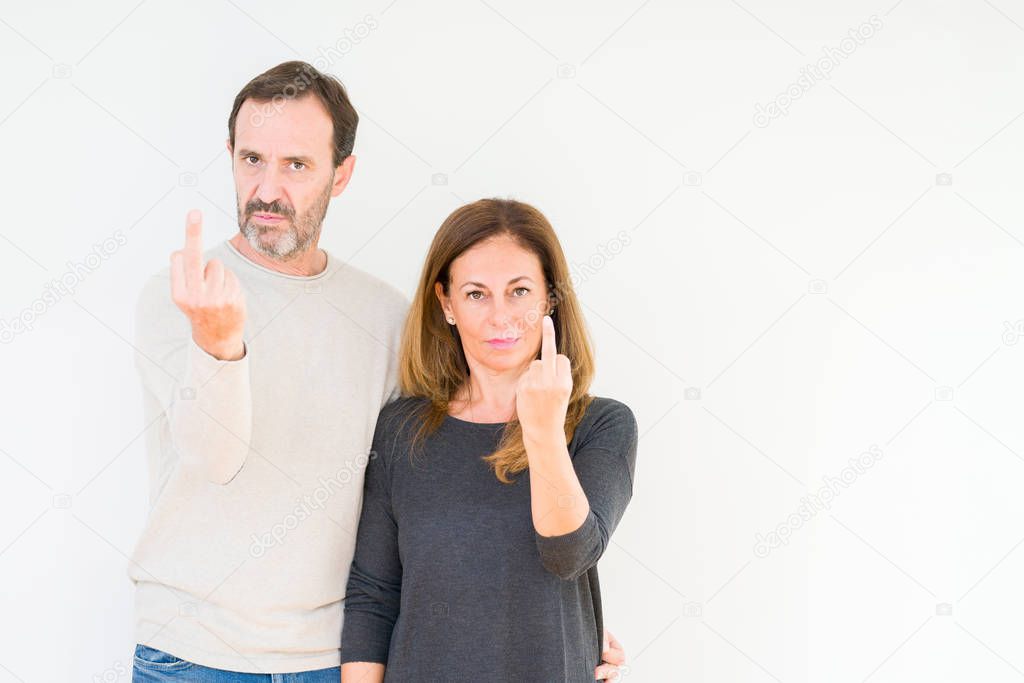 Beautiful middle age couple in love over isolated background Showing middle finger, impolite and rude fuck off expression