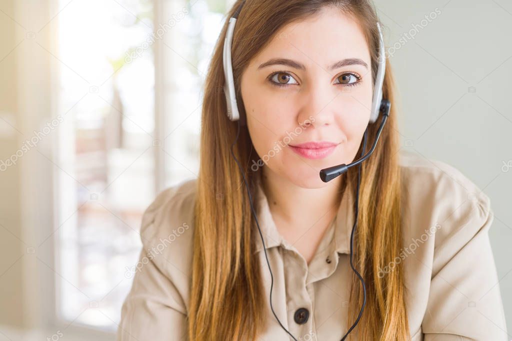 Beautiful young operator woman wearing headset at the office Relaxed with serious expression on face. Simple and natural with crossed arms