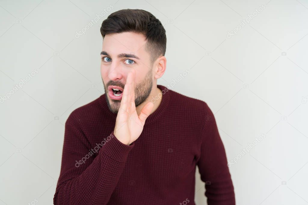 Young handsome man wearing a sweater over isolated background hand on mouth telling secret rumor, whispering malicious talk conversation