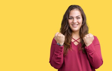 Artı boyutu genç kadın izole arka plan güzel kutlama şaşırttı ve başarı için kaldırdı kollarını açarak hayrete ve gözleri açık. Kazanan kavramı.