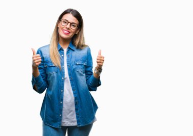 Gözlük el ile pozitif jest yapıyor izole arka plan başarı işareti üzerinde genç güzel kadın başparmak gülümseyen ve mutlu. Neşeli bir ifadeyle, kazanan jest kameraya bakıyor.