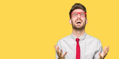 Çılgın ve kızgın bağırarak ve agresif ifade ve silah kaldırdı bağırmaya gözlüklü genç yakışıklı iş adamı. Hayal kırıklığı kavramı.