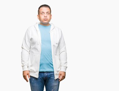 Orta yaş Arap adam komik surat ile yanakları şişirme izole arka plan üzerinde kazak giyiyor. Ağız ile hava, deli ifade şişirilmiş.