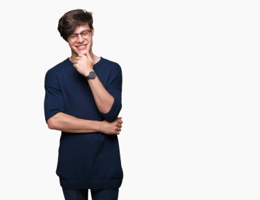 Emin çapraz kollar ve çeneme kaldırdı el ile gülümseme ile kameraya bakarak izole arka plan üzerinde gözlük takan yakışıklı delikanlı. Pozitif düşünce.