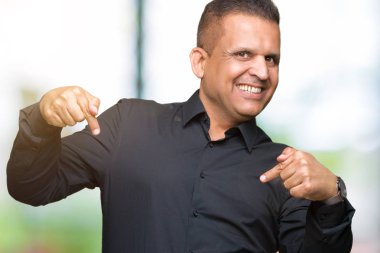 Yakışıklı orta yaş Arap iş adamı yüzünde gülümseme ile kendinden emin görünüyorsun, kendini gururlu ve mutlu parmakları ile işaret izole arka plan üzerinde.