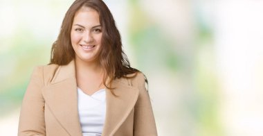 Artı boyutu genç kadın güzel üzerinde kış palto giyiyor arka plan eller birlikte izole ve rahat ve neşeli gülümseyen parmak çarpı işareti. Başarı ve iyimser