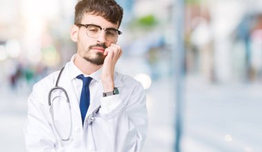 Seyir yorgun ve bıkkın ile depresyon sorun Çapraz kollar ile izole arka plan düşünme üzerine hastane ceket giyen adam genç doktor.