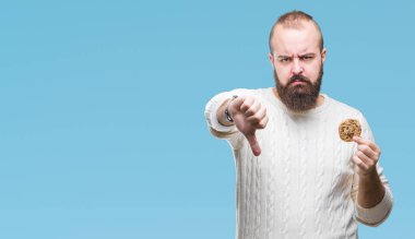 Kızgın yüz, eksi işareti aşağı antipati başparmak ile gösterilen, ret kavramı ile izole arka plan üzerinde çerez genç hipster adam yeme çikolata cips