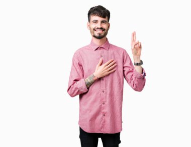 Pembe gömlek izole üzerinde giyen genç yakışıklı adam arka plan Swearing göğüs ve parmaklar, el ile bir sadakat sözü yemin yapma