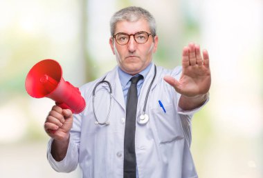 Yakışıklı kıdemli Doktor adam megafon ile izole arka plan üzerinde açık eliyle dur işareti ile ciddi ve kendine güvenen ifade, savunma hareketi yaparken bağırıyor