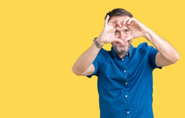 İzole arka plan yaparken kalp şekli ile el ve parmak işareti seyir gülümseyen yakışıklı orta yaş zarif üst düzey adam