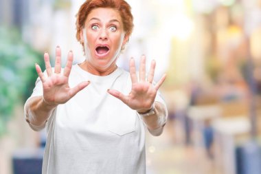 Şokta bağırarak Atrractive üst düzey beyaz Kızıl saçlı kadın izole arka plan korkuyor ve korku ifade dur hareketi el ile ile çok korkmuş. Panik kavramı.