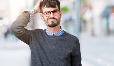 Genç yakışıklı gözlük izole arka plan üzerinde şaşırtmak ve soru hakkında merak ediyorum adam akıllı. Şüphe, kafasına el ile düşünme ile belirsiz. Dalgın kavramı.