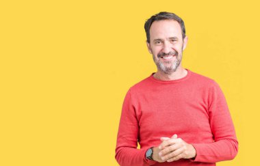 Arka plan eller üzerinde kış kazak giymiş yakışıklı orta yaş ağarmış komuta sizde birlikte izole ve rahat ve neşeli gülümseyen parmak çarpı işareti. Başarı ve iyimser