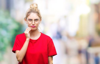 Diş ağrısı veya dişlerde dişlerle ilgili hastalık nedeniyle ağız acı ifadesi ile el ile dokunmak izole arka plan üzerinde kırmızı t-shirt ve gözlük giyen genç güzel sarışın kadın. Diş hekimi kavramı.