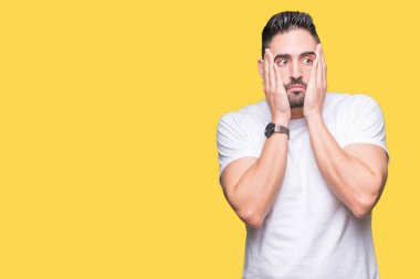Yakışıklı adam sarı izole arka plan yorgun eller kat yüz, depresyon ve üzüntü, üzerinde beyaz t-shirt giyen üzgün ve sorun için tahriş