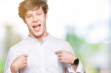 Genç yakışıklı iş adamı yüzünde gülümseme ile kendinden emin görünüyorsun, kendini gururlu ve mutlu parmakları ile işaret izole arka plan üzerinde.