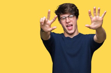 Gösterilen arka plan üzerinde gözlük takan genç yakışıklı adam izole ve parmakları ile işaret kendinden emin ve mutlu gülümseyerek süre 8 numaralı.