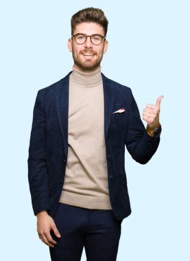 Hareketi el ile mutlu yaşasın yapıyor gözlüklü genç yakışıklı iş adamı. Kameraya bakarak başarı gösteren ile ifade onaylama.