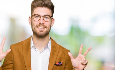 Gösterilen ve parmakları ile işaret genç yakışıklı iş adam gözlük kendinden emin ve mutlu gülümseyerek süre sekiz numara.