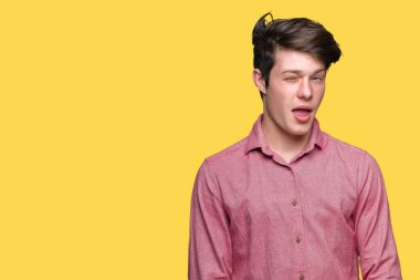 Genç yakışıklı iş adamı seksi bir ifadeyle, neşeli ve mutlu yüzünü kameraya bakarak göz kırpıyor izole arka plan üzerinde.