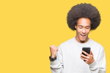 Gurur çığlık ve zafer ve başarı çok heyecanlı, kutlama bir smartphone kullanarak afro saçlı genç Afro-Amerikan adam duygu tezahürat