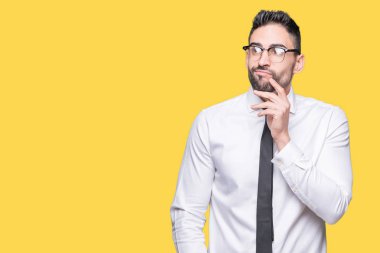 Çene düşünme hakkında soru, dalgın ifade üzerine el ile izole arka plan üzerinde gözlük takan genç yakışıklı iş adamı. Düşünceli yüzüyle gülümsüyor. Şüphe kavramı.