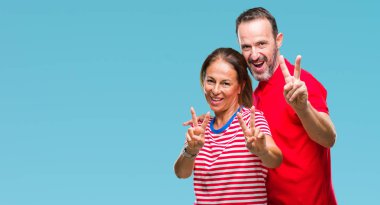 Orta yaş İspanyol çift kamera zafer işareti yapıyor parmak gösteren seyir gülümseyen izole arka plan üzerinde aşık. İki numaralı.