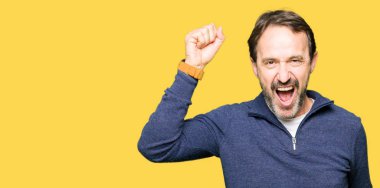 Rahat ve kendinden emin müzik hareket gülümseyen mutlu ve neşeli, dans bir kazak giyen orta yaş yakışıklı adam