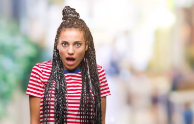 Genç örgülü saç Afro-Amerikan kız korkuyor ve şok sürpriz ifade, korku ve heyecan yüz ile izole arka plan üzerinde.