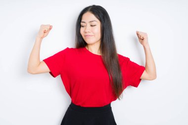 Kol kasları gururlu gülümseyen gösterilen izole arka plan üzerinde kırmızı t-shirt giyen güzel esmer kadın. Fitness kavramı.