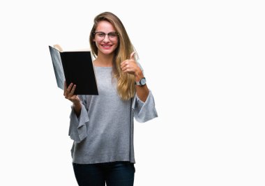 Genç güzel sarışın kadın ok işareti, başparmak ile parmak, mükemmel işareti yapıyor kocaman bir gülümseme ile izole arka plan üzerinde mutlu bir kitap okuma