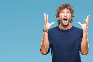 Yakışıklı İspanyol izole arka plan deli üzerinde kış kazak giyen adam model ve deli bağırarak ve agresif ifade ve silah kaldırdı bağırıyor. Hayal kırıklığı kavramı.