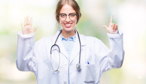 美丽的年轻金发碧眼的医生妇女穿着医疗制服在孤立的背景显示和手指指向数字 而微笑着自信和快乐 — 图库照片