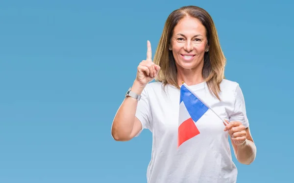 幸せそうな顔 ナンバーワンのアイデアや質問ポインティング指で孤立した背景にフランスの旗を保持している中年ヒスパニック女性を驚かせた — ストック写真