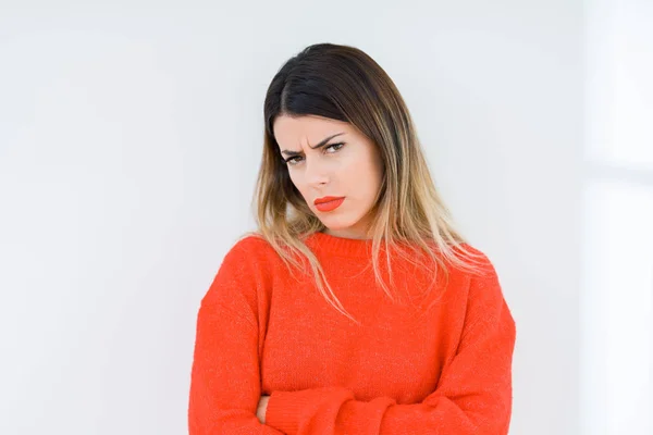懐疑的な孤立した背景と組んだ腕で顔の神経 不賛成式カジュアルな赤いセーターを着た若い女性 否定的な人 — ストック写真