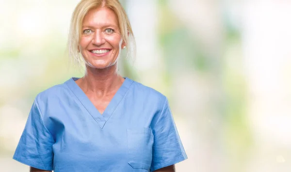 Middle age blonde woman wearing doctor nurse uniform over isolated background with a happy and cool smile on face. Lucky person.