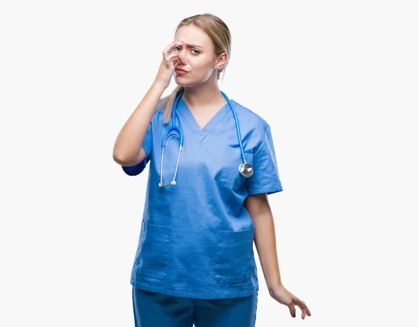 年轻的金发医生在孤立的背景下的女人闻到的东西臭气熏天 无法忍受的气味 用手指在鼻子上屏住呼吸 难闻的气味概念 — 图库照片