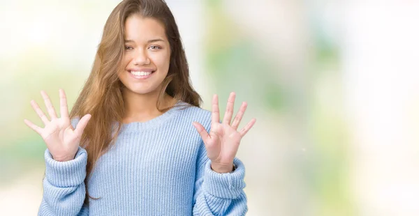 年轻美丽的黑发女人穿着蓝色的冬季毛衣在孤立的背景显示和手指数字十 而微笑着自信和快乐 — 图库照片