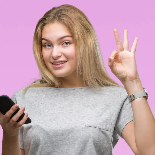 若い白人女性 優秀なシンボルの指で サインを行う分離の背景にスマート フォンを使用してメッセージを送信します — ストック写真