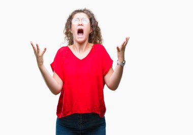 Güzel esmer kıvırcık saçlı Genç kız üzerinde gözlük takan arka plan deli izole ve deli bağırarak ve agresif ifade ve silah kaldırdı bağırıyor. Hayal kırıklığı kavramı.