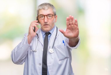 Smarpthone üzerinde açık eliyle dur işareti ile ciddi ve kendine güvenen ifade, savunma jest yapıyor izole arka plan üzerinde konuşan yakışıklı kıdemli Doktor adam