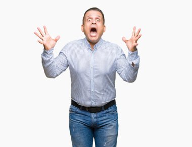 Orta yaş Arap iş adam deli kutluyor arka plan izole ve başarı için kaldırdı kollarını açarak hayrete ve heyecanlı çığlık gözleri açık. Kazanan kavramı