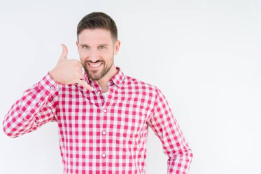 Yakışıklı delikanlı yapıyor gülümseyen izole arka plan üzerinde gömlek giymiş telefon hareketi ile el ve parmak telefonda konuşuyor gibi. Kavramları iletişim.