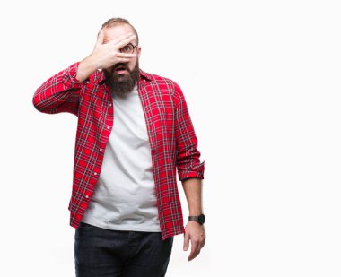 Yüz ve gözler el ile kapsayan şok izole arka plan bakmak üzerinde gözlük takan Genç beyaz hipster adam utanç ifadesi ile parmaklarımın arasından bakan.